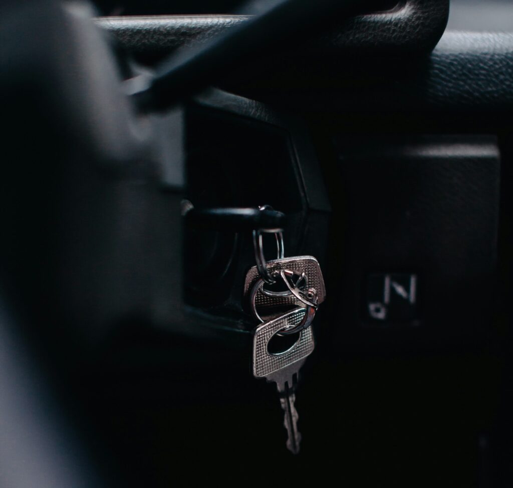 A set of keys dangling from the ignition of a car.