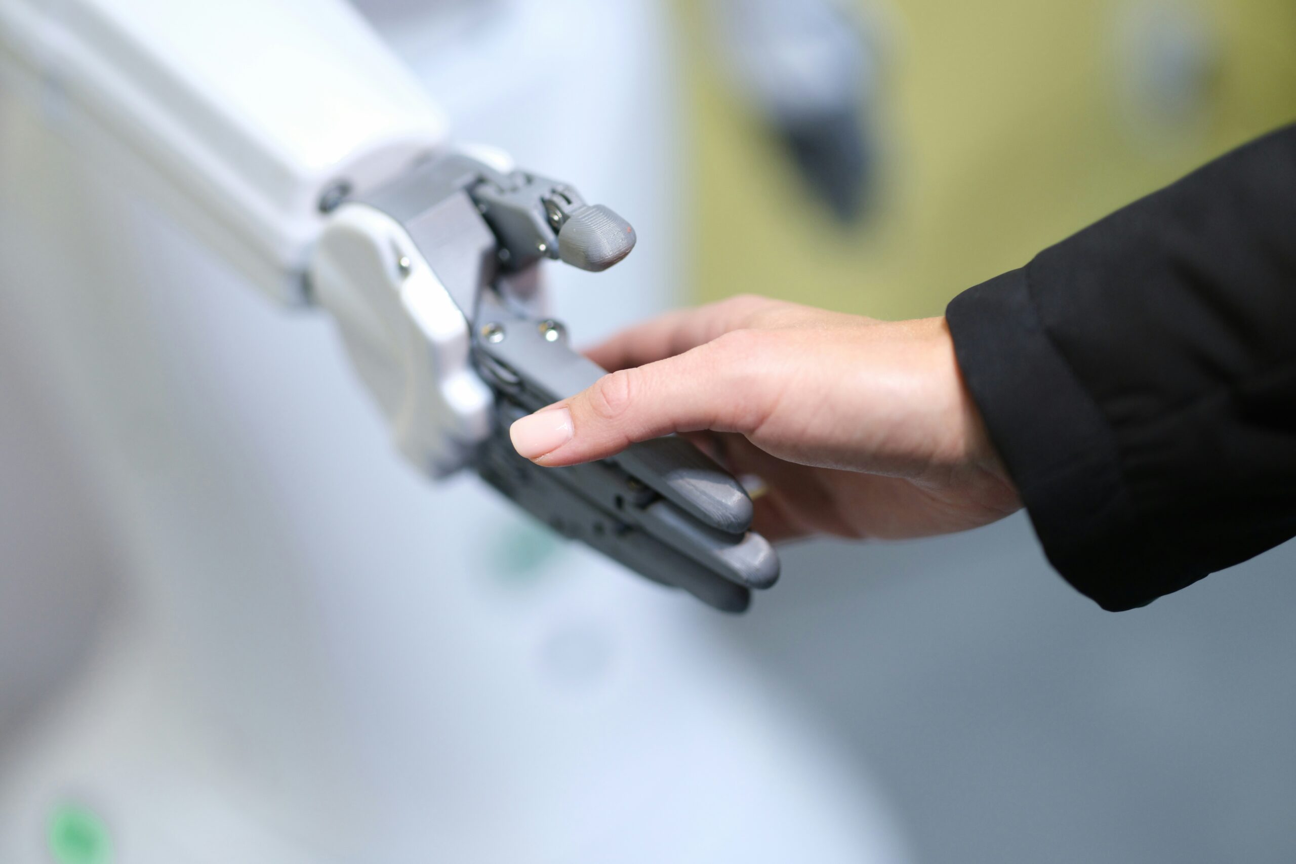 human hand holding a robot hand as if in a handshake