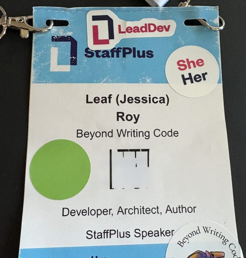 StaffPlus badge for Leaf (Jessica) Roy, Beyond Writing Code, Developer Architect Author, StaffPlus Speaker. It has stickers that say "LeadDev", "She Her" and "Beyond Writing Code"
