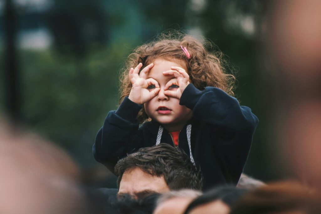 Girl holding her hands over her eyes as if she were looking through binoculars